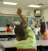 Photo Children in classroom raising hands
